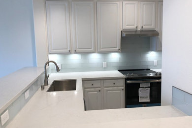Enclosed kitchen - mid-sized contemporary u-shaped laminate floor and gray floor enclosed kitchen idea in San Francisco with an undermount sink, raised-panel cabinets, gray cabinets, quartzite countertops, gray backsplash, subway tile backsplash, stainless steel appliances, no island and white countertops