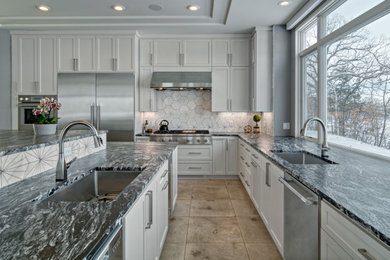 Example of a transitional l-shaped tray ceiling eat-in kitchen design in Minneapolis with an undermount sink, recessed-panel cabinets, white cabinets, granite countertops, metallic backsplash, marble backsplash, stainless steel appliances, two islands and gray countertops