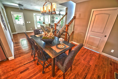 This is an example of a transitional open plan dining in St Louis with beige walls and medium hardwood floors.