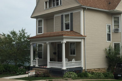 This is an example of a mid-sized traditional front porch design in Cedar Rapids.