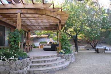 Huge transitional backyard patio kitchen photo in San Francisco with an awning