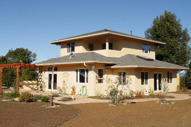 Example of a mid-sized classic beige two-story stucco house exterior design in San Francisco with a clipped gable roof and a shingle roof