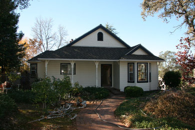 Imagen de fachada de casa de estilo de casa de campo de tamaño medio a niveles con revestimiento de madera, tejado a la holandesa y tejado de teja de madera