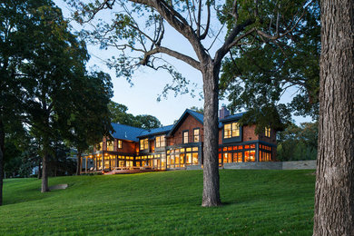 Example of a huge arts and crafts brown two-story wood exterior home design in Minneapolis with a mixed material roof