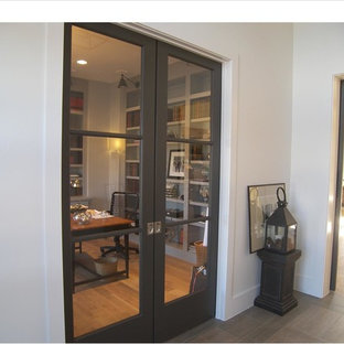 Новые идеи обустройства дома: фойе в стиле модернизм с белыми стенами, черной входной дверью, светлым паркетным полом и раздвижной входной дверью