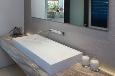 Inspiration for a contemporary powder room remodel in Los Angeles with a trough sink and marble countertops