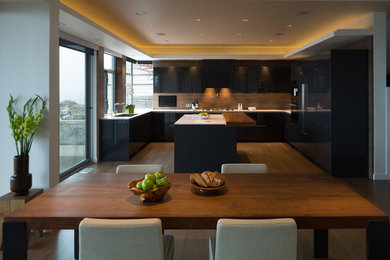 Inspiration for a large modern u-shaped medium tone wood floor and brown floor eat-in kitchen remodel in Seattle with flat-panel cabinets, an island, an undermount sink, brown cabinets, quartz countertops, brown backsplash, stainless steel appliances and white countertops