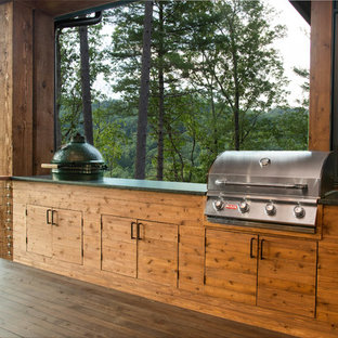 Photo of a mid-sized country backyard patio in Other with an outdoor kitchen, decking and a roof extension.