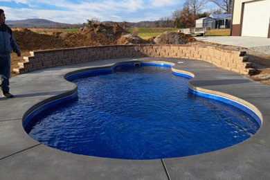 Inspiration for a mid-sized timeless backyard concrete and custom-shaped pool remodel in Louisville