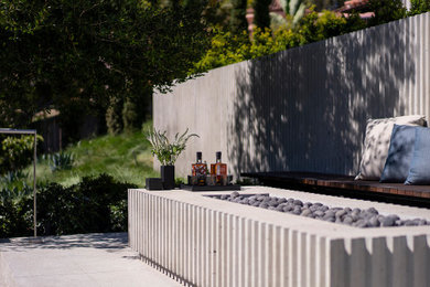 Design ideas for a mid-sized mediterranean backyard concrete paver formal garden in San Diego with a fireplace.