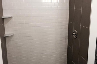 Large elegant master multicolored tile and stone tile pebble tile floor bathroom photo in Detroit with a drop-in sink, recessed-panel cabinets, black cabinets, granite countertops and gray walls