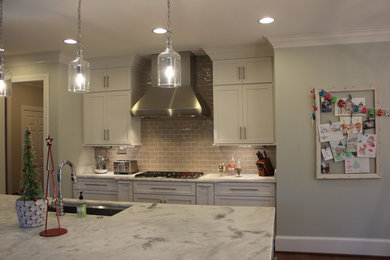 Inspiration for a transitional l-shaped kitchen remodel in Other with shaker cabinets, white cabinets and an island