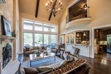Inspiration for a large country formal open concept living room in Dallas with beige walls, dark hardwood floors, a standard fireplace, a stone fireplace surround, no tv and brown floor.