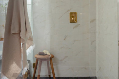 Corner shower - traditional 3/4 beige tile and porcelain tile ceramic tile, black floor and single-sink corner shower idea in Portland with beige walls, an undermount sink, black countertops and a freestanding vanity