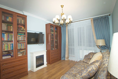 Modelo de salón cerrado tradicional pequeño con todas las chimeneas, marco de chimenea de madera y televisor colgado en la pared