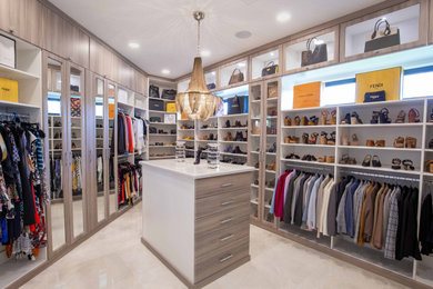 Inspiration for a huge contemporary women's marble floor and beige floor walk-in closet remodel in Miami with glass-front cabinets and medium tone wood cabinets