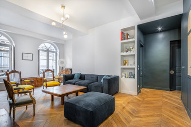 Diseño de salón abierto tradicional renovado de tamaño medio con paredes azules y suelo de madera clara