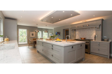Large transitional galley medium tone wood floor, brown floor and tray ceiling eat-in kitchen photo in Los Angeles with an undermount sink, shaker cabinets, gray cabinets, marble countertops, white backsplash, stainless steel appliances, an island and white countertops