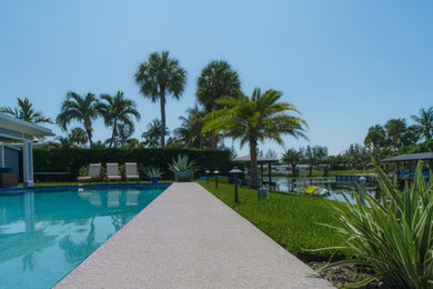 Deck - mid-sized contemporary backyard ground level privacy and glass railing deck idea in Miami with a pergola