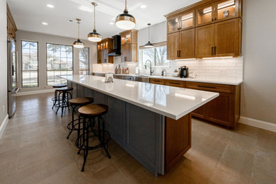 Inspiration for a huge contemporary porcelain tile and brown floor eat-in kitchen remodel in Dallas with a farmhouse sink, shaker cabinets, medium tone wood cabinets, quartz countertops, white backsplash, subway tile backsplash, stainless steel appliances, an island and white countertops