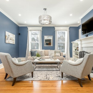 This is an example of a medium sized traditional enclosed family and games room in Columbus with blue walls, a standard fireplace, a wall mounted tv, medium hardwood flooring and beige floors.