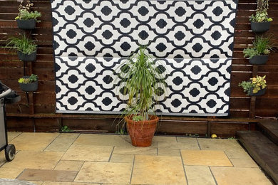 This is an example of a mid-sized contemporary backyard patio in San Francisco with natural stone pavers.