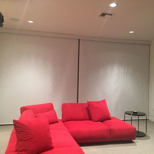 Large modern enclosed home cinema in San Diego with beige walls, carpet and a projector screen.