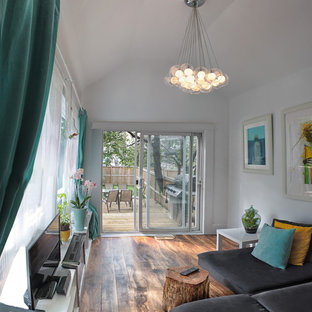 Foto di un piccolo soggiorno chiuso con sala giochi, pareti bianche, pavimento in legno massello medio, camino classico e TV autoportante