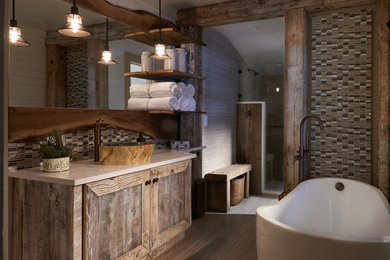 Large mountain style master multicolored tile and glass tile porcelain tile, gray floor, single-sink and shiplap ceiling bathroom photo in Other with recessed-panel cabinets, distressed cabinets, beige walls, a vessel sink, quartz countertops, a one-piece toilet and a built-in vanity