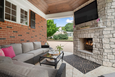 Design ideas for a large traditional back veranda in St Louis with a fireplace, stamped concrete and a roof extension.