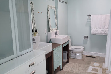 Example of a small eclectic kids' multicolored tile and mosaic tile porcelain tile, beige floor, double-sink and wallpaper bathroom design in Minneapolis with recessed-panel cabinets, green cabinets, a one-piece toilet, blue walls, a trough sink, wood countertops, green countertops and a built-in vanity
