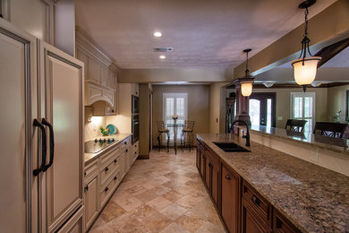 This is an example of a large transitional galley open plan kitchen in Atlanta with a double-bowl sink, raised-panel cabinets, beige cabinets, granite benchtops, white splashback, panelled appliances, limestone floors and no island.
