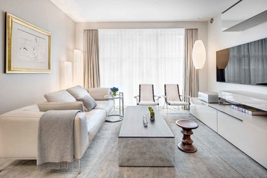 Example of a mid-sized trendy formal and enclosed carpeted and gray floor living room design in New York with a wall-mounted tv, white walls and no fireplace