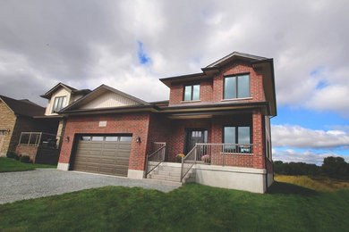Large trendy red two-story mixed siding gable roof photo in Toronto