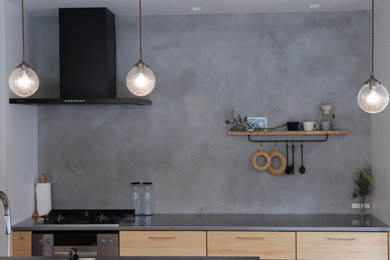 Imagen de cocina moderna pequeña abierta con fregadero integrado, encimera de acero inoxidable y papel pintado