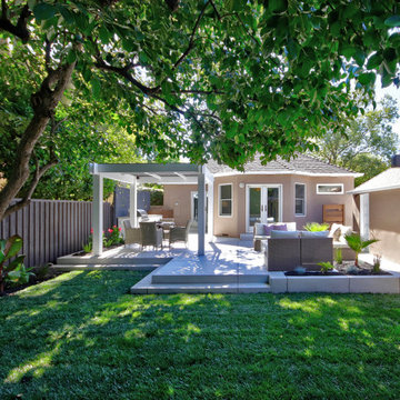 Inviting Backyard with Raised Patio, Pergola, and Outdoor Kitchen