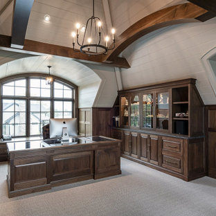 Großes Arbeitszimmer mit Arbeitsplatz, weißer Wandfarbe, Teppichboden, Einbau-Schreibtisch, beigem Boden, Holzdielendecke und vertäfelten Wänden in Grand Rapids