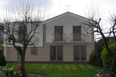 Immagine della villa beige contemporanea di medie dimensioni con rivestimento in stucco, tetto a capanna e copertura in tegole