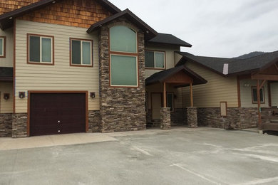 Inspiration for a large timeless beige two-story mixed siding house exterior remodel in Other