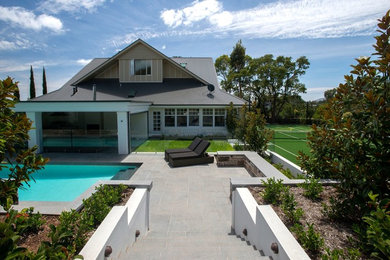 This is an example of a large contemporary backyard pool in Adelaide with natural stone pavers.