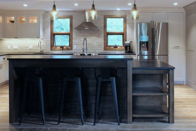 Large transitional u-shaped medium tone wood floor open concept kitchen photo in Calgary with an undermount sink, shaker cabinets, soapstone countertops, ceramic backsplash, stainless steel appliances and an island