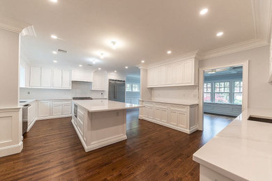 Inspiration for a huge transitional l-shaped enclosed kitchen remodel in New York with shaker cabinets, white cabinets, white backsplash, an island and white countertops