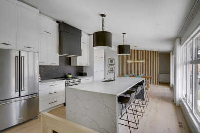 Kitchen - transitional light wood floor kitchen idea in Calgary with an undermount sink, shaker cabinets, quartzite countertops, gray backsplash, ceramic backsplash, stainless steel appliances, an island and white countertops