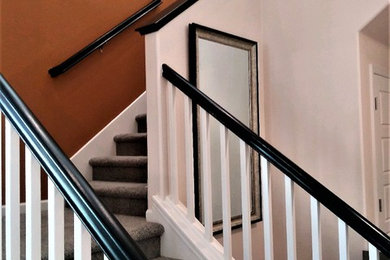 Imagen de escalera minimalista de tamaño medio con escalones enmoquetados y barandilla de madera