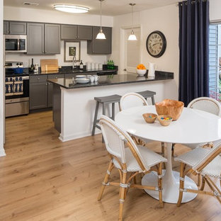 Idee per una sala da pranzo aperta verso la cucina tradizionale di medie dimensioni con pareti bianche e pavimento in laminato