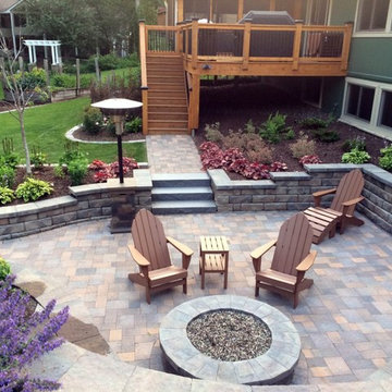 Backyard patio with gas fire pit, retaining walls and full landscape.