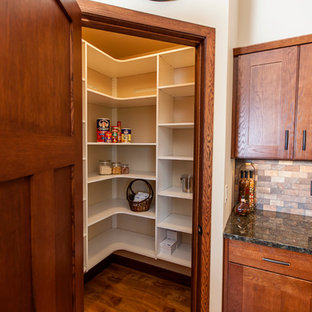 Mid-sized craftsman kitchen pantry remodeling - Example of a mid-sized arts and crafts l-shaped light wood floor kitchen pantry design in Milwaukee with a double-bowl sink, shaker cabinets, dark wood cabinets, granite countertops, multicolored backsplash, stone tile backsplash, stainless steel appliances and an island