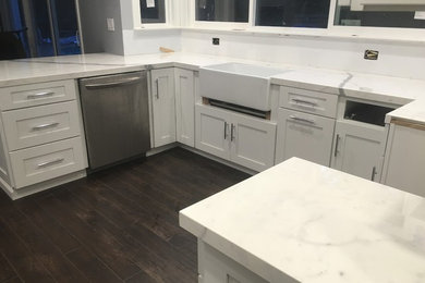 Eat-in kitchen - mid-sized modern l-shaped eat-in kitchen idea in San Francisco with white cabinets, laminate countertops and an island