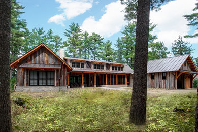 Rustic two-story wood exterior home idea in Other with a metal roof