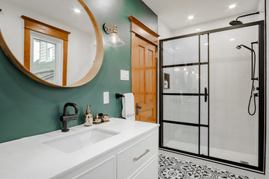 This is an example of a large country master bathroom in Toronto with furniture-like cabinets, white cabinets, an alcove shower, a one-piece toilet, green tile, green walls, cement tiles, an undermount sink, engineered quartz benchtops, a sliding shower screen and white benchtops.